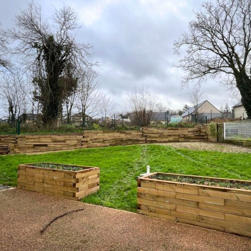 Transformation du jardin avec un mur de soutènement et des jardinières surélevées